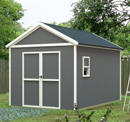 A small Outdoor Wood Storage Shed gray shed with white trim and a dark roof stands on a grassy area near a wooden fence, surrounded by trees. A ladder leans against the shed's side, highlighting the versatility of this Outdoor Wood Storage Shed, perfect for an 8x12 storage shed setup.