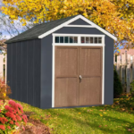 Outdoor Wood Storage Shed. A small storage shed situated in a yard, surrounded by grass and plants, providing a neat storage solution